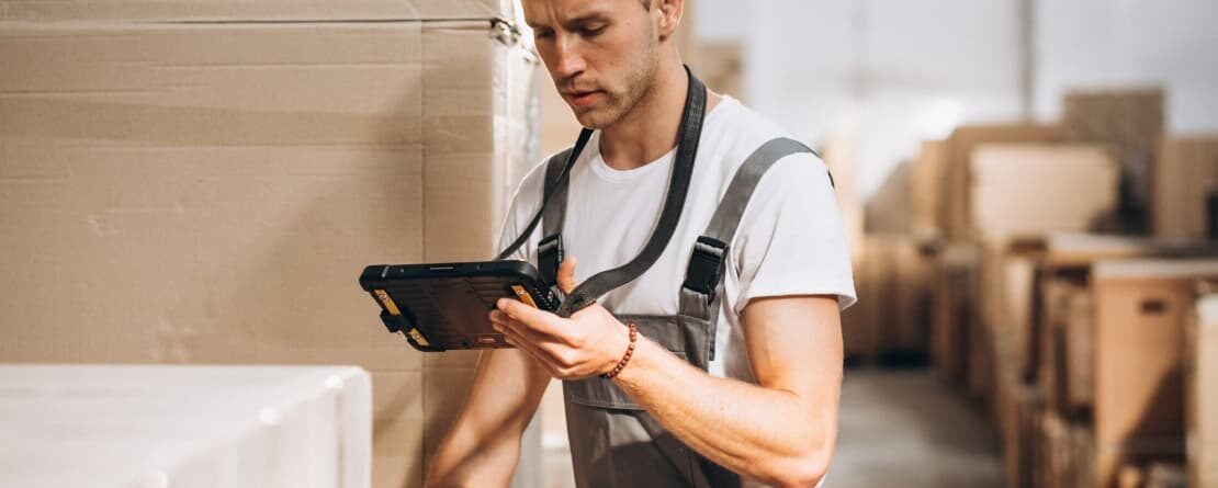 a man in a warehouse looking at a tablet