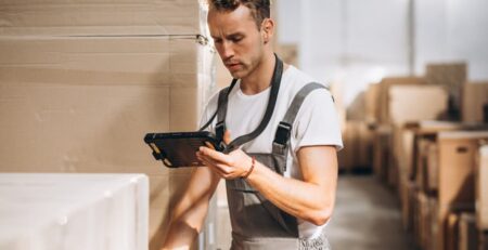 a man in a warehouse looking at a tablet