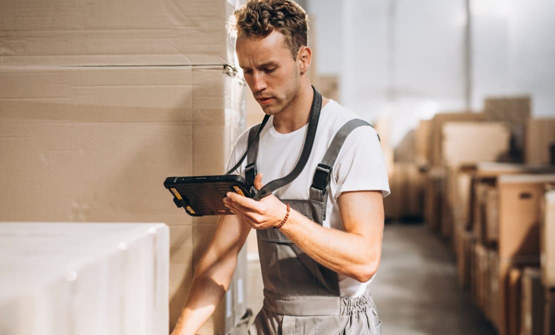 a man in a warehouse looking at a tablet