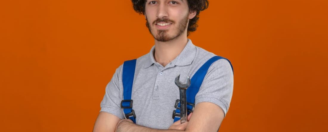 a man in overalls with his arms crossed
