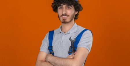 a man in overalls with his arms crossed