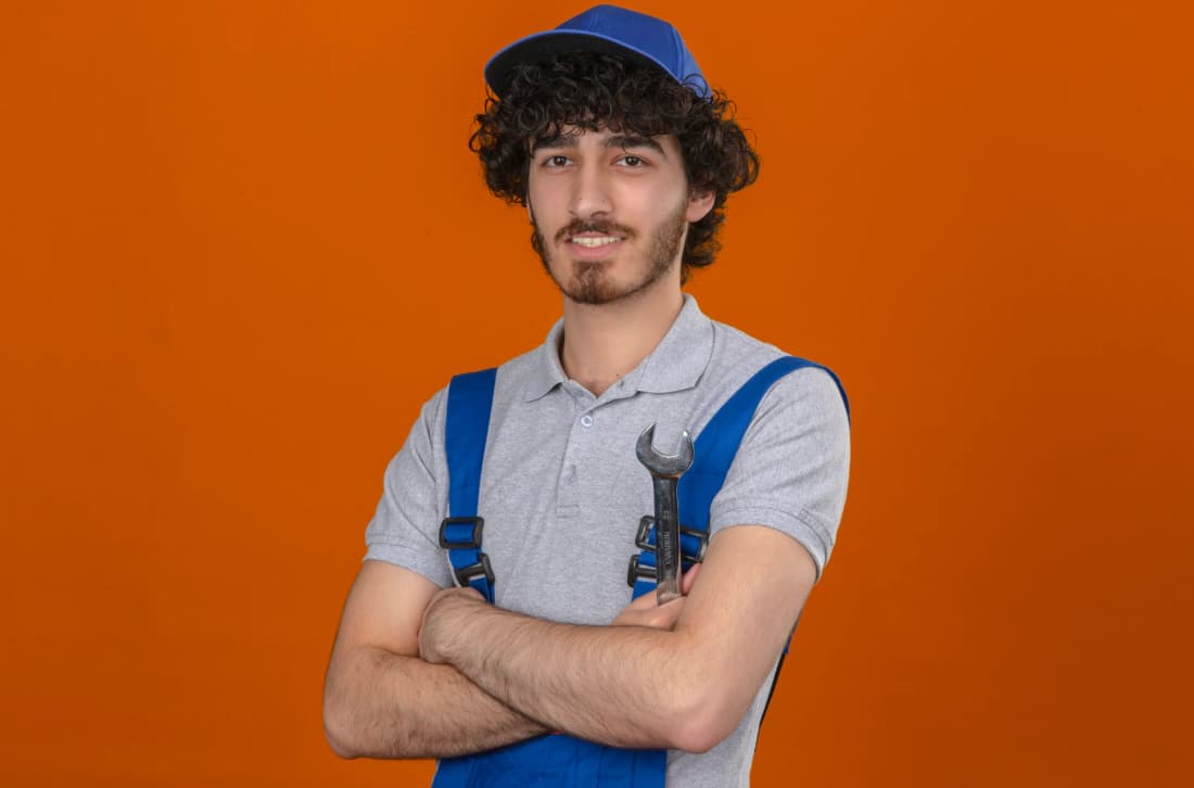 a man in overalls with his arms crossed